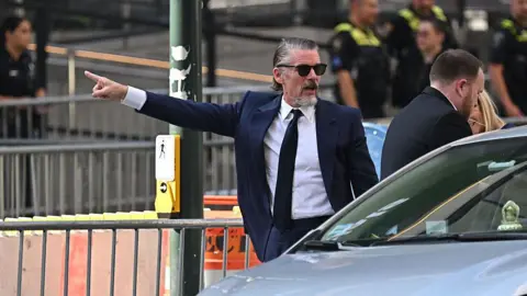 Getty Images Ethan Hawke points his arm as he arrives at Madison Square Garden on 3 July. 