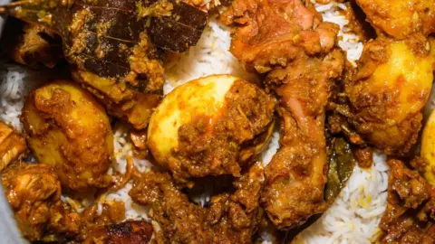 NurPhoto via Getty Images A pot of biryani, with aromatic basmati rice, cooked chicken, eggs and dry spices