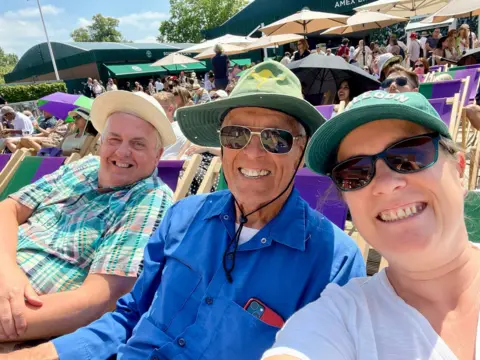 Supplied Lucy and her friends Richard and Phil are sitting in deckchairs in the Wimbledon grounds 