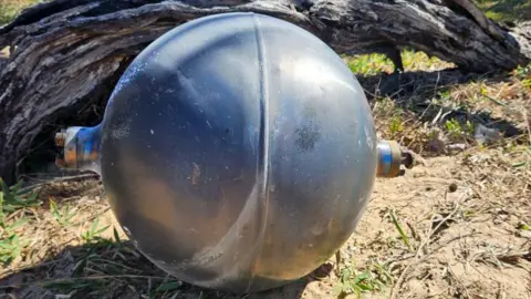 Queensland Fire Department One of the six mysterious large silver spheres washed up on Forrest Beach in Queensland