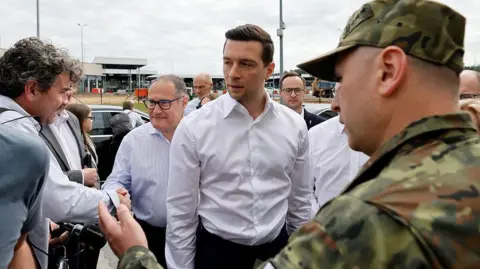 AFP via Getty Images French far-right Rassemblement National (RN) party's President, member of the European Parliament and president of the Patriots for Europe (PfE) group Jordan Bardella (C) arrive for a visit to Poland's border with Belarus near Kuznica, eastern Poland