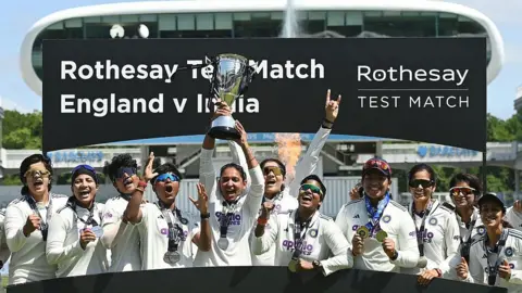 Getty Images  India captain Harmanpreet Kaur holds the trophy up after India won the 1st Women's Rothesay Test match against England at Lord's Cricket Ground on July 13, 2026 in London, England. (Photo by Philip Brown/Getty Images)