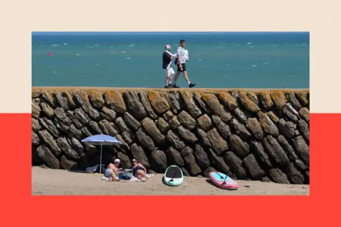 PA People experiencing the hot weather on Sunny Sands beach in Folkestone, Kent.