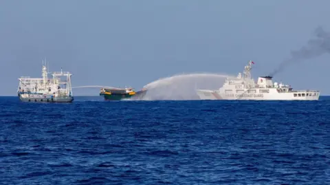 Reuters A file photo of two Chinese Coast Guard vessels blasting water cannons at a Philippine boat