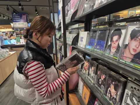 Gyu-ri browses K-pop albums at a music store in Seoul
