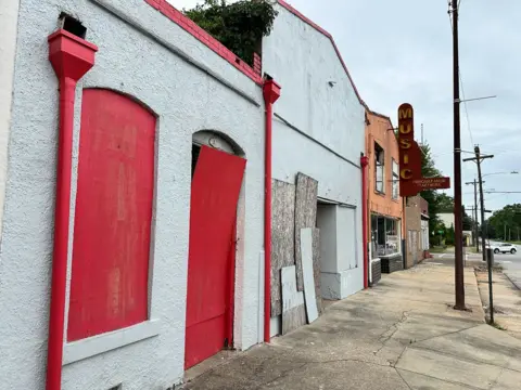 Brandon Drenon/BBC  A row of deserted buildings on Tuskegee's South Main Street 