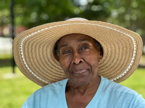 Getty Images Mary Porter wears a straw hat and a blue t-shirt