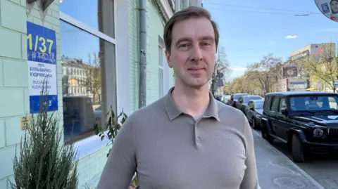 Ivan Stupak stands on a street in Kyiv, looking into the camera