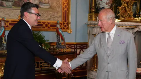 PA Media King Charles III shaking hands with Andy Burnham, during an audience at Buckingham Palace