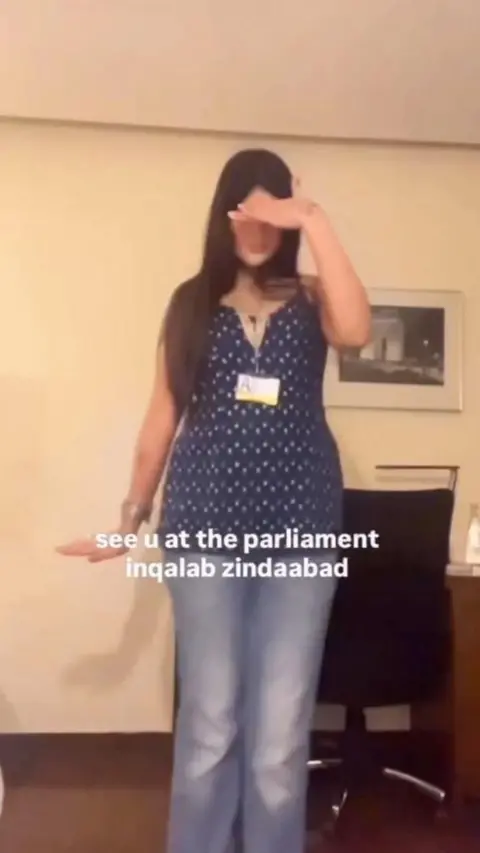 Deeva Arora A girl posing for the camera, as she shows the outfit she is wearing to the protest