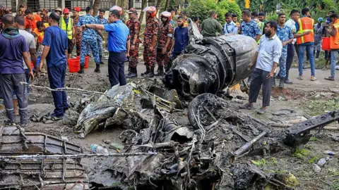 Getty Images Bangladesh's fire service and security personnel conduct a search and rescue operation after an Air Force training jet crashed into a school in Dhaka