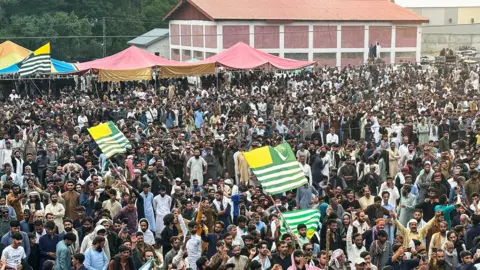 Getty Images Supporters of the Joint Awami Action Committee (JAAC) gather during a week-long protest in Rawalakot, in Pakistan-administered Kashmir on June 24, 2026, following the group's ban under anti-terrorism laws by local authorities. A nearly two-week standoff between protesters and police in Pakistan-administered Kashmir has left residents grappling with food shortages, while the death toll from clashes rose to 22, according to an AFP tally on June 17. (Photo by AFP via Getty Images)