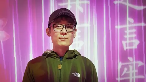Family handout Jang Deok-jun, a young Korean man, is seen wearing a cap and a dark hoodie against a pink background.
