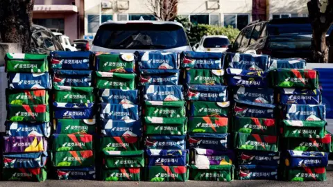 Getty Images Coupang ''Rocket Fresh'' reusable delivery bags are stacked in front of an apartment complex in Yeouido, Seoul, on December 18, 2025. 