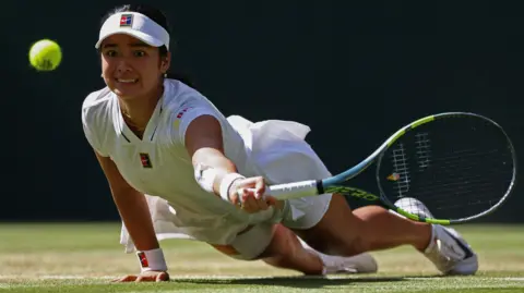 Reuters Eala dives stretching for ball with raquet