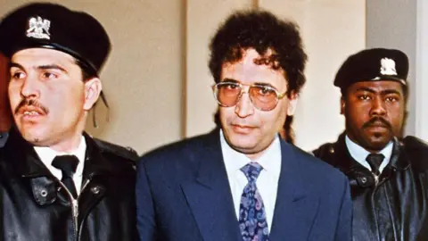 Getty Images File photo taken February 18, 1992 in Tripoli shows convicted Lockerbie bomber Abdelbaset Ali Mohmet al-Megrahi (C) being escorted by security officers. The Libyan convicted of the Lockerbie bombing could be allowed to fly home to die over the next seven days, 21 years after the atrocity plunged Libya's ties with the West into a prolonged standoff, reports suggested on August 16, 2009. 