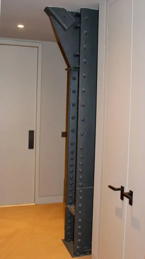 Grace Eliza Goodwin A steel support beam exposed in a hallway