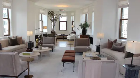 Grace Eliza Goodwin View of triangular shaped apartment living room, with modern furniture, high ceiling, and windows all around