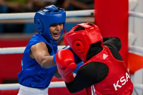 AFP via Getty Images Saudi Arabia's Ashour Hadeel Ghazwan and India's Jaismine Lamboria (blue) compete in their women's 57-60Kg preliminary round boxing match during the Hangzhou 2022 Asian Games in Hangzhou, on September 28, 2023. (Photo by Ishara S. KODIKARA / AFP) (Photo by ISHARA S. KODIKARA/AFP via Getty Images)