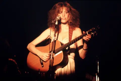 Getty Images Carly Simon in the 1970s playing guitar