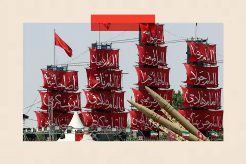 AFP via Getty Images Ships with red sails and Farsi script with missiles in front of them at a military celebration in Iran