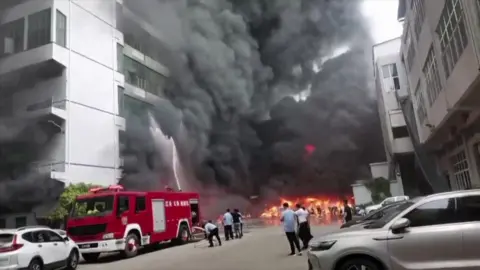 CCTV/AFP Plumes of black smoke and flames can be seen as a fire truck sprays a burning building with water