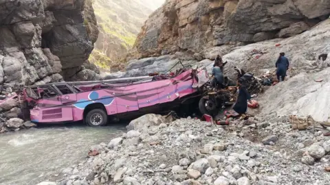 District Administration Sherani A bus badly damaged after crashing into a ravine