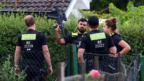 Reuters Four police officers are pictured, with one officers holding a gun up