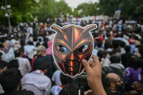 AFP via Getty Images A Cockroach Janta Party (CJP) supporter wearing a cockroach mask at a protest over alleged irregularities in major public examinations in Delhi

