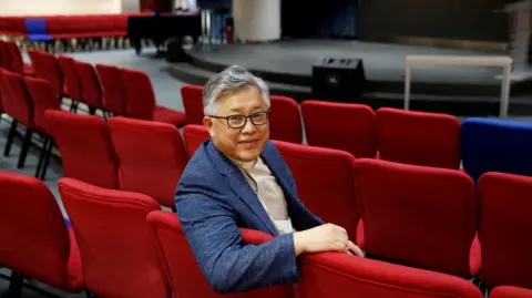 Reuters/ Thomas Peter/ File Photo The head pastor of the Zion church in Beijing Jin Mingri poses for picures in the congregation hall of the unofficial Protestant "house" church in Beijing, China, 2018.