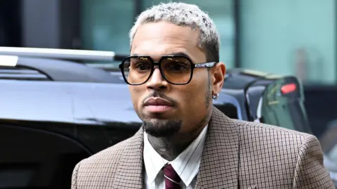 Reuters U.S. singer Chris Brown, who has been charged with inflicting grievous bodily harm in what prosecutors said was an "unprovoked attack" on a music producer at the Tape nightclub in central London in 2023, walks outside the Southwark Crown Court in London, Britain, July 11, 2025.