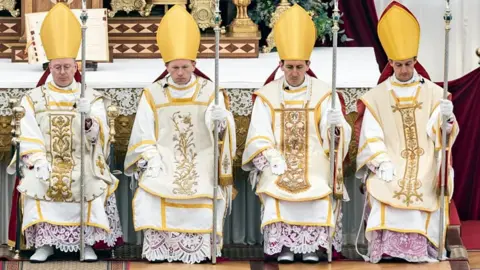 EPA/Shutterstock (L-R) Catholic priests Pascal Schreiber of Switzerland, Michael Goldade of United States, Michel Poinsinet de Sivry of France, and Marc Hanappier of France wear the bishop's mitre after receiving episcopal consecration during a pontifical mass organized by Society of Saint Pius X (SSPX) in Econe, near Sion, Switzerland.