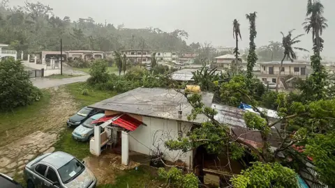 Getty Images This picture shows a general view of a residential area as rain falls ahead of the arrival of the forecasted Super Typhoon Bavi in Saipan, Northern Mariana Islands, on July 5, 2026.