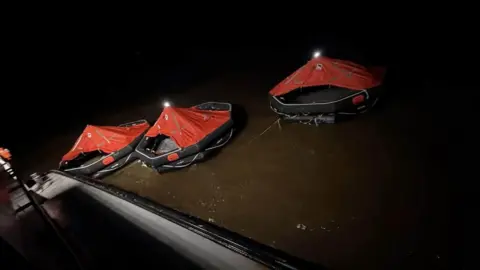 Prime Minister Mark Phillips Several inflatable lifeboats in the water. 