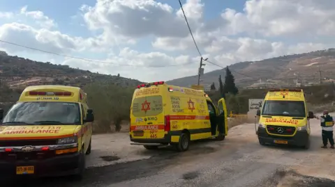 Magen David Adom Three yellow ambulances parked at scene of West Bank shooting incident (24/07/26)