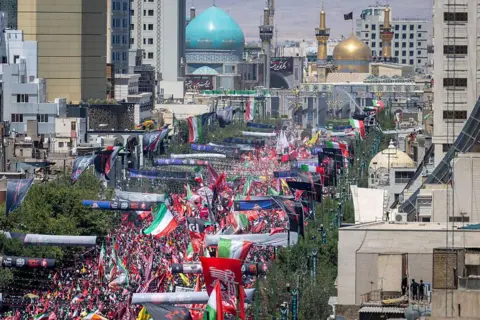 Getty Images Thousands of mourners gather on a boulevard in Mashhad, northeastern Iran, ahead of the burial of Iran's late Supreme Leader Ayatollah Ali Khamenei (9 July 2026)