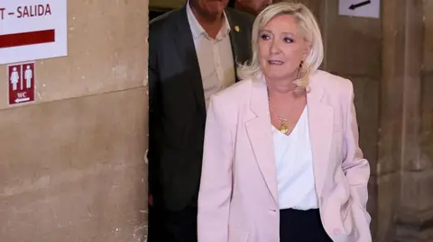 AFP via Getty Images President of far-right party Rassemblement National (RN) parliamentary group Marine Le Pen arrives to attend the verdict in the appeal trial of RN former or actual members on charges of embezzlement 