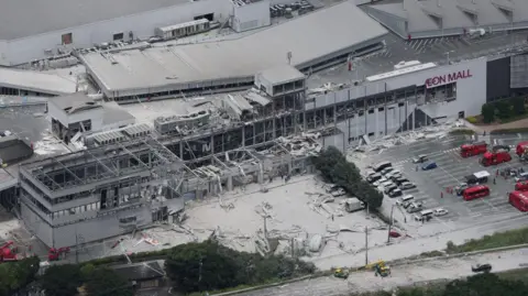EPA An aerial shot of Aeon Mall which has collapsed with debris surrounding the building