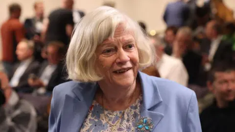 Getty Images Ann Widdecombe smiles as she looks to the right. She is wearing a blue blazer and a flowery blue and white top. 