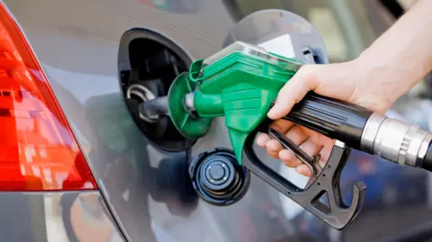 Getty Images A petrol pump nozzle being inserted into a car's petrol tank