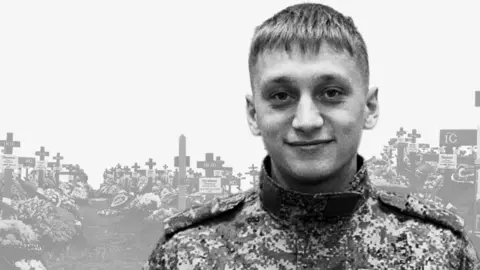 VK/Kyakhtinsky District Valery Averin in uniform stands in front of an image of a cemetery
