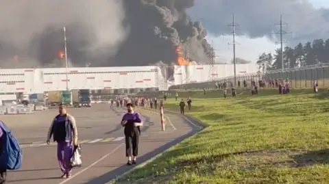 social media people walk away from a burning warehouse