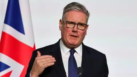 Reuters Sir Keir Starmer in front of a UK flag