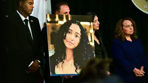 AFP via Getty Images A portrait of the late Celeste Rivas Hernandez is shown during a press briefing by Los Angeles County District Attorney Nathan J. Hochman (out of frame) on the case against singer D4vd in Los Angeles, on April 20, 2026. 
