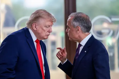 Getty Images US President Donald Trump speaks with Canada's Prime Minister Mark Carney during a work lunch as part of the G7 summit, in Evian, eastern France, on 16 June 2026.
