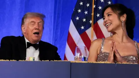 Reuters Trump reacts next to CBS News senior White House correspondent and White House Correspondents' Association President (WHCA) Weijia Jiang at the WHCA Dinner