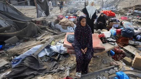 Reuters Palestinians inspect the site of Wednesday's Israeli strike on a house whose residents were pre-warned by the Israeli military to evacuate, in Gaza City