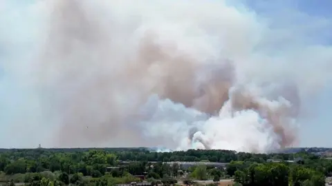 AFP via Corentin Baudry A screenshot from a video showing a massive plume of smoke rising from a fire near Bordeaux-Mérignac airport, south-western France. Photo: 21 July 2026