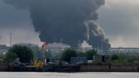Zelenskiy / Official Screenshot from a video showing St Petersburg's oil terminal on fire in north-western after a Ukrainian attack. 