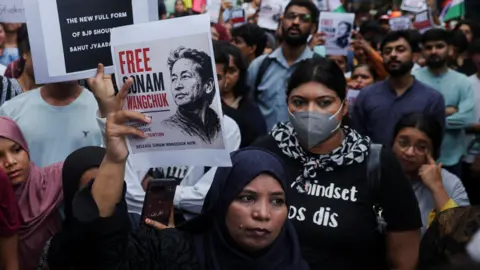 Reuters Supporters of the Cockroach Janta Party (CJP) hold posters of Sonam Wangchuk after authorities moved him to a hospital during his hunger strike, during a protest demanding the resignation of Indian Education Minister Dharmendra Pradhan, in Mumbai, India, July 19, 2026. 